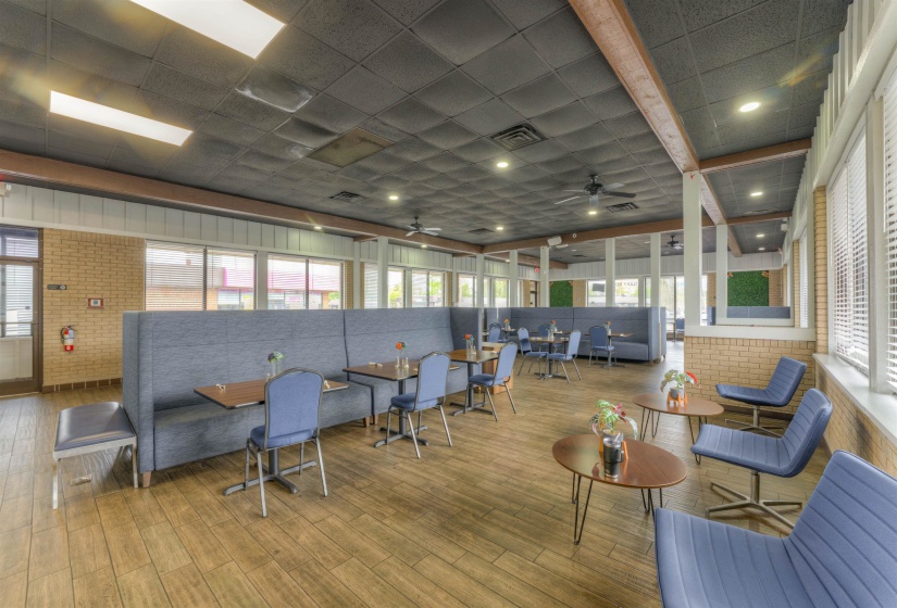 Common area featuring a paneled ceiling and brick wall
