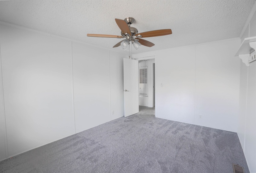 Unfurnished room with carpet floors, ceiling fan, and a textured ceiling