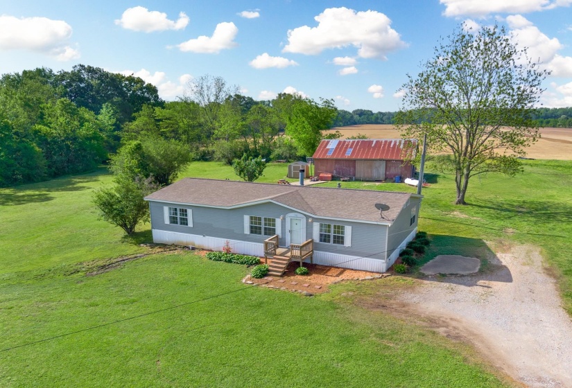 View of front facade with a front lawn, a shingled roof, and driveway