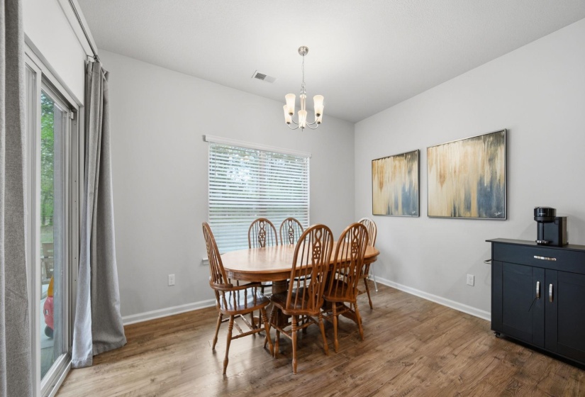 Dining area with plenty of natural light, wood finished floors, and hanging lights