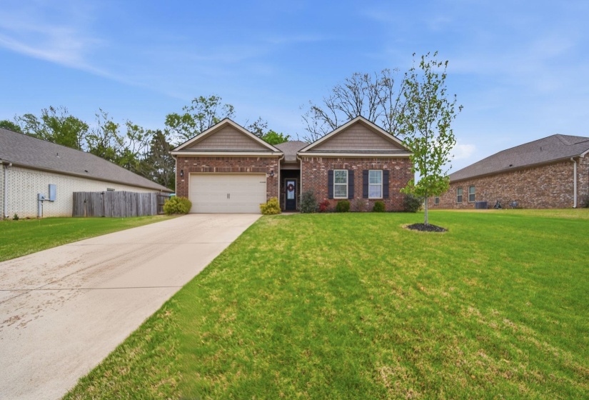 View of front of property with a garage, driveway, and brick siding