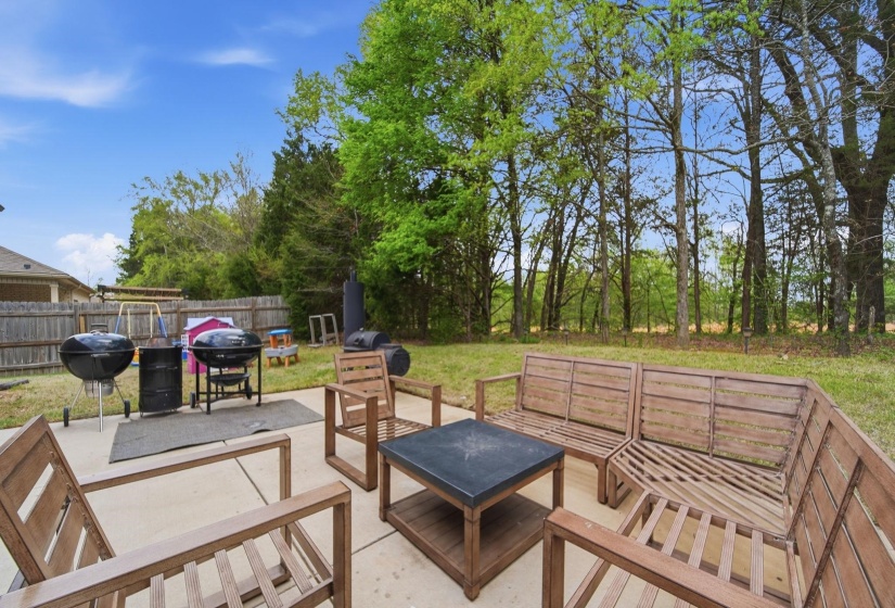 Fenced backyard featuring outdoor seating, a patio area, and a grill