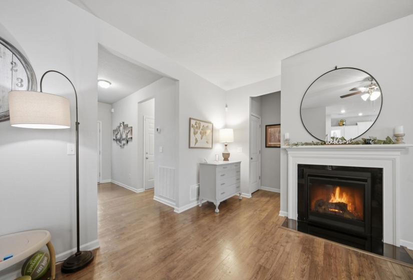Full bathroom featuring two vanities, a glass covered fireplace, and wood finished floors