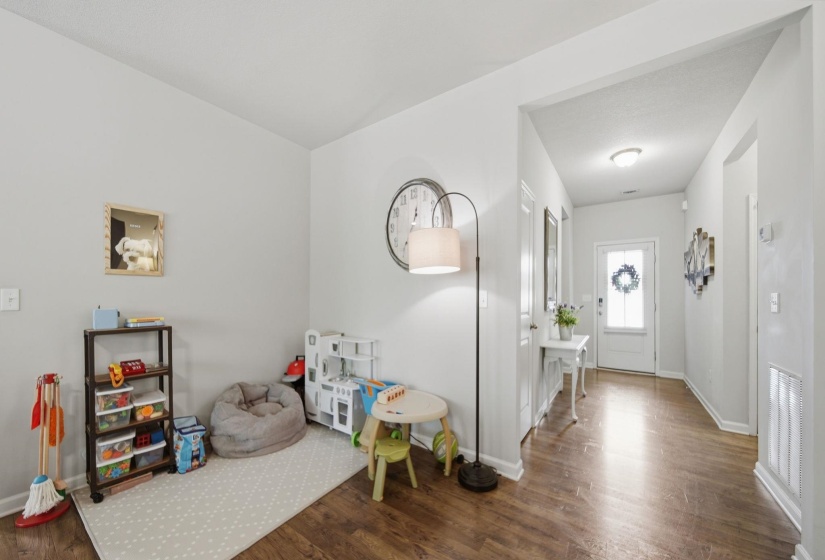 Entrance foyer with dark wood-style flooring and baseboards