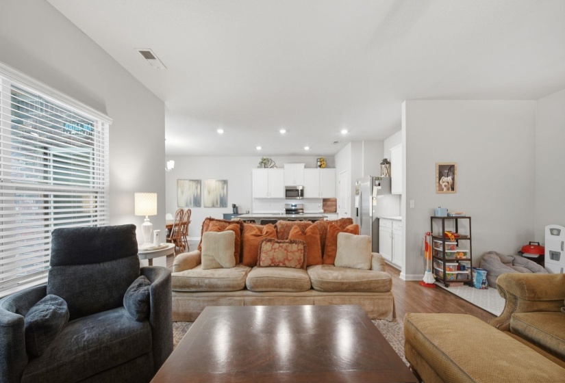 Living room with light wood-style flooring and recessed lighting