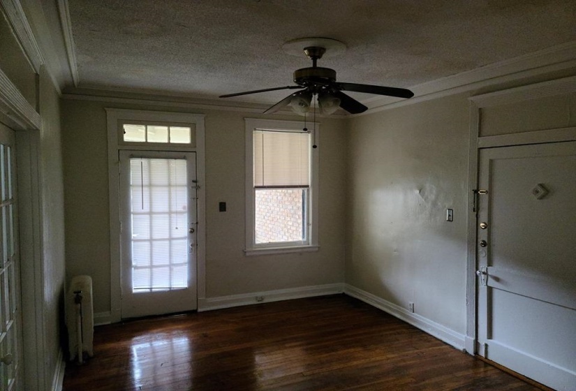 Entrance foyer featuring ornamental molding, a textured ceiling, a ceiling fan, dark wood finished floors, and radiator heating unit