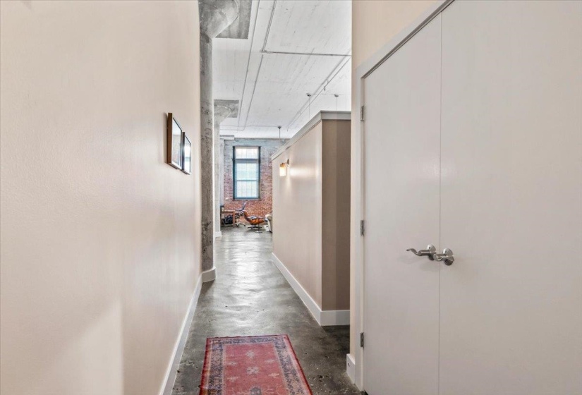 Hallway featuring baseboards and finished concrete floors