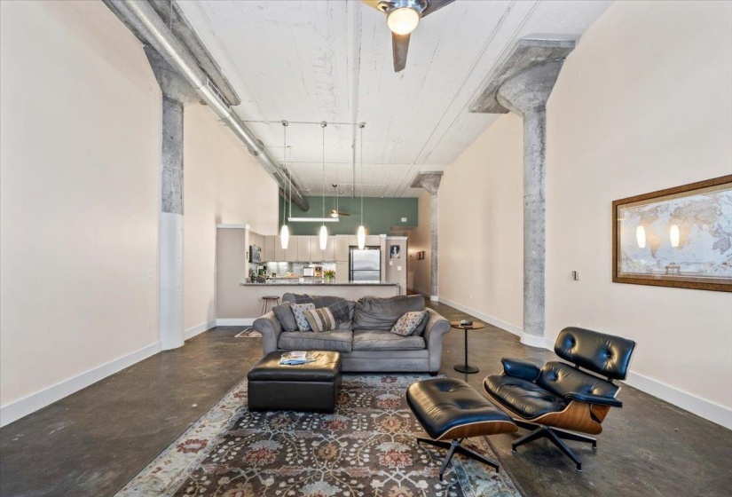 Living area featuring concrete floors and a high ceiling