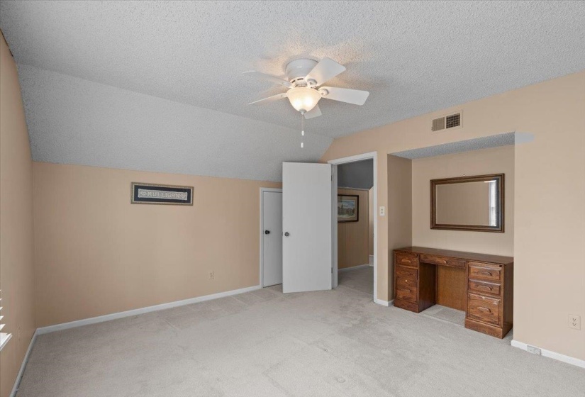 Unfurnished bedroom with light carpet and a ceiling fan