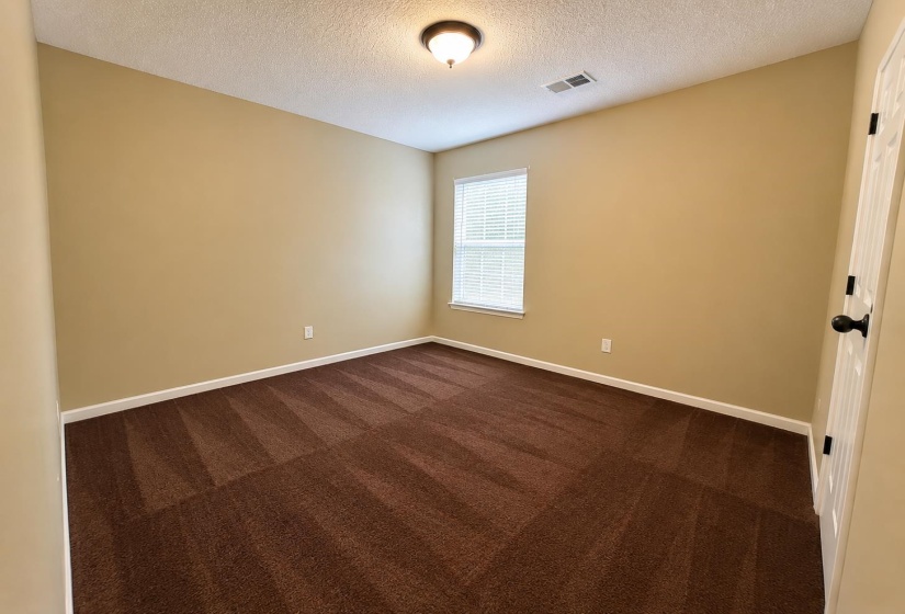 Room featuring textured brown carpeting and neutral tone walls