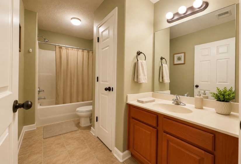 Bathroom featuring a full vanity with an integrated sink, a large mirror, and a three-light fixture