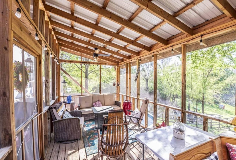 Sunroom / solarium featuring an outdoor living space with a fire pit, a wooden deck, and lofted ceiling