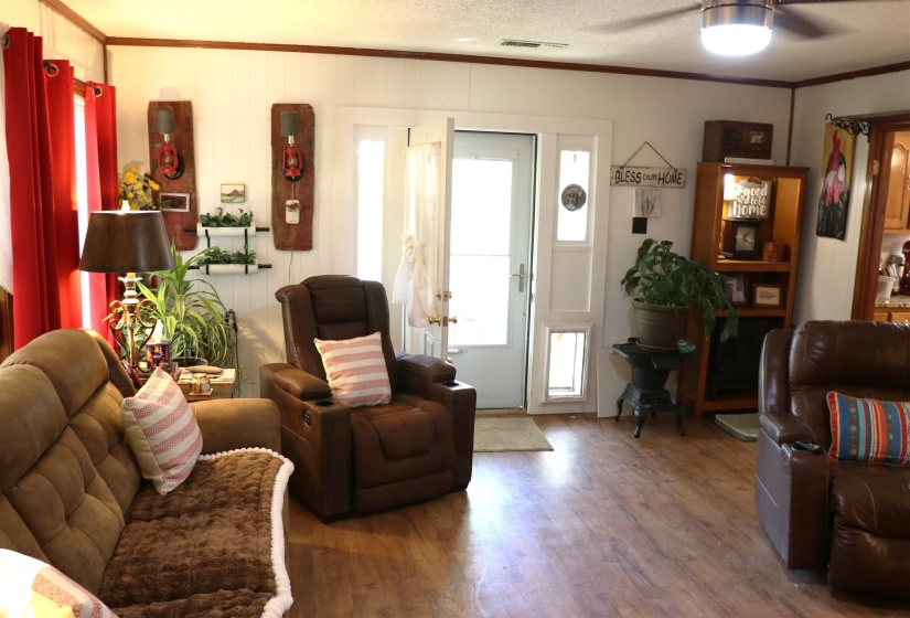Living room featuring ornamental molding, wood finished floors, and ceiling fan