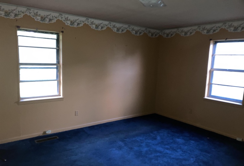 Bedroom with dark colored carpet and baseboards