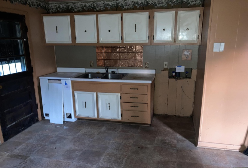Kitchen featuring stone finish floors and white cabinetry