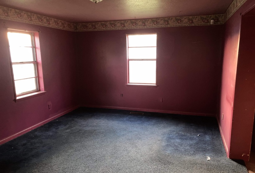 Great room featuring dark colored carpet and a textured ceiling