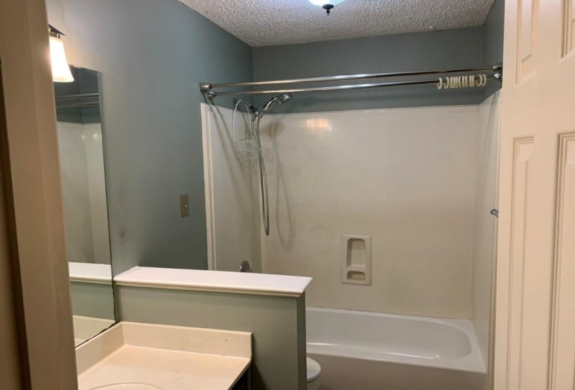 Bathroom featuring a white tub and shower combination with a curved shower rod