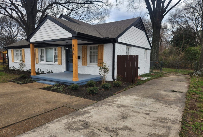View of front of property featuring brick siding, covered porch, and concrete driveway