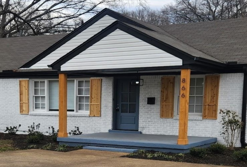 Entrance to property with covered porch and brick siding