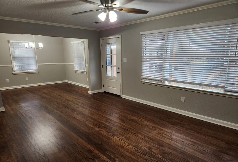 Entryway featuring a textured ceiling, a ceiling fan, dark wood-type flooring, crown molding, and a chandelier