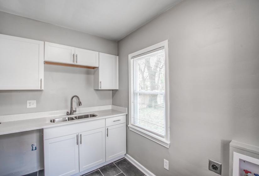 Kitchen with white cabinets and dark tile patterned floors