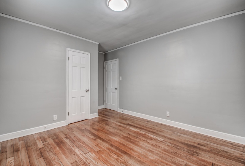 Spare room with crown molding and light wood finished floors