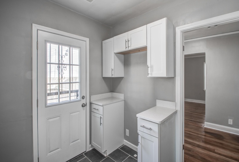Laundry room with baseboards and dark wood-style floors