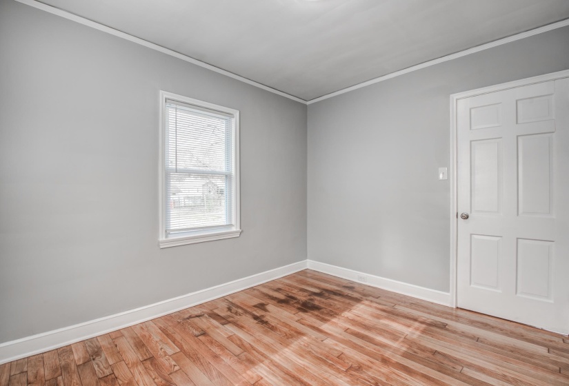 Spare room featuring crown molding and light wood finished floors