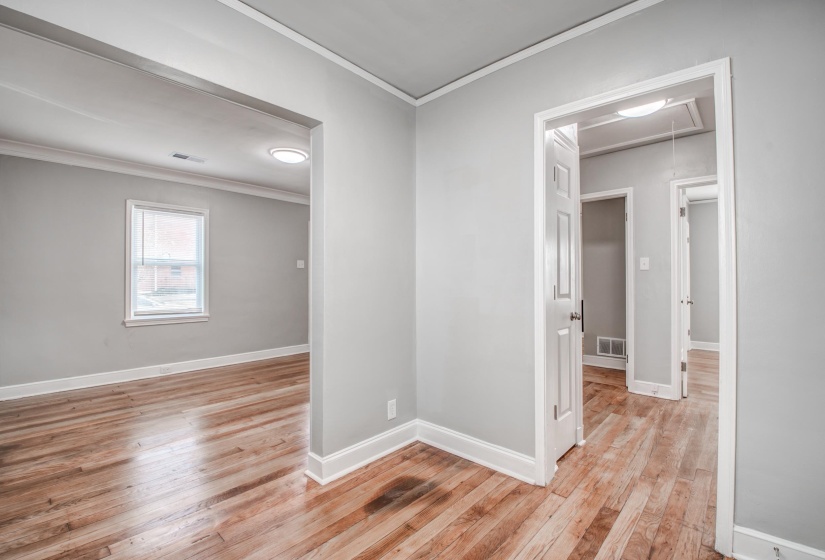 Empty room featuring ornamental molding and light wood-type flooring