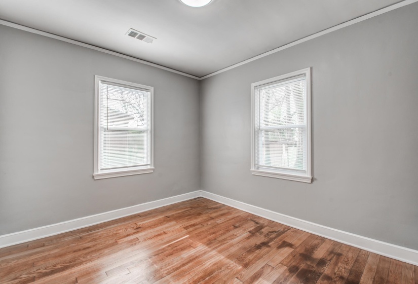 Unfurnished room with crown molding, light wood-style flooring, and plenty of natural light