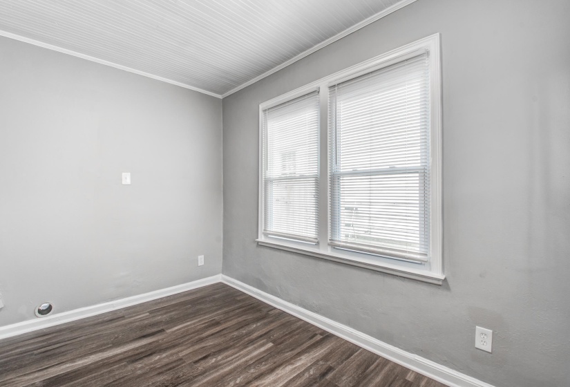 Spare room with ornamental molding and dark wood finished floors