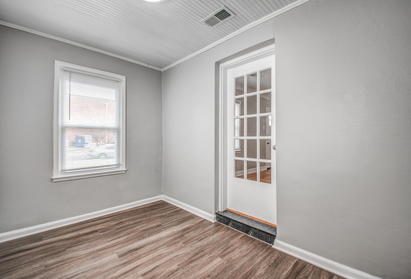 Spare room featuring wood finished floors and crown molding