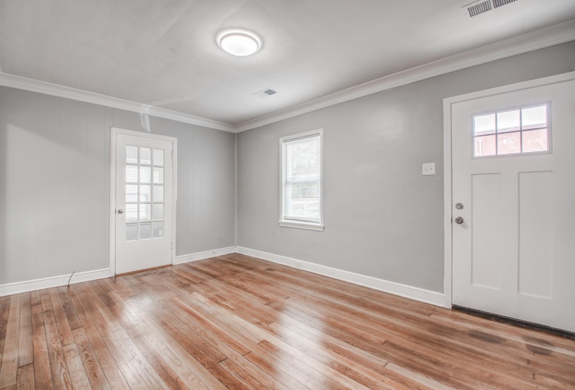 Entrance foyer featuring crown molding and light wood-style flooring