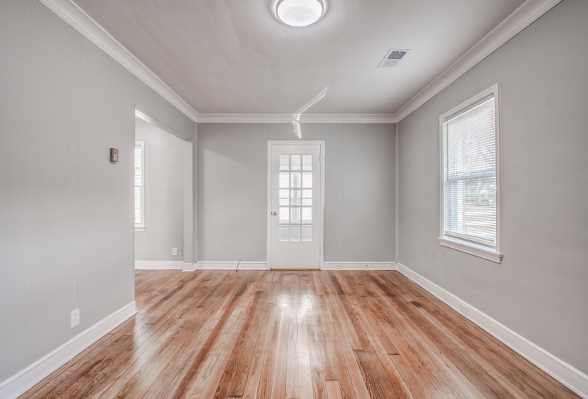 Unfurnished room featuring light wood finished floors, ornamental molding, and plenty of natural light