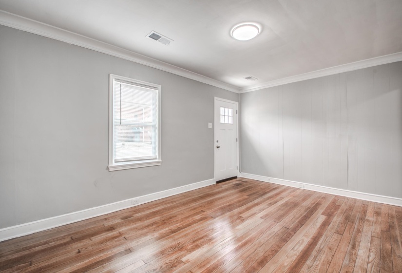 Entryway with crown molding and light wood-style flooring