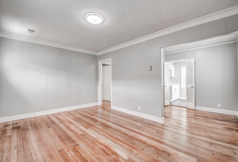 Spare room featuring crown molding and light wood-style flooring