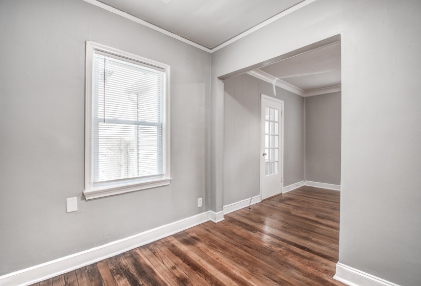 Empty room with crown molding and dark wood finished floors