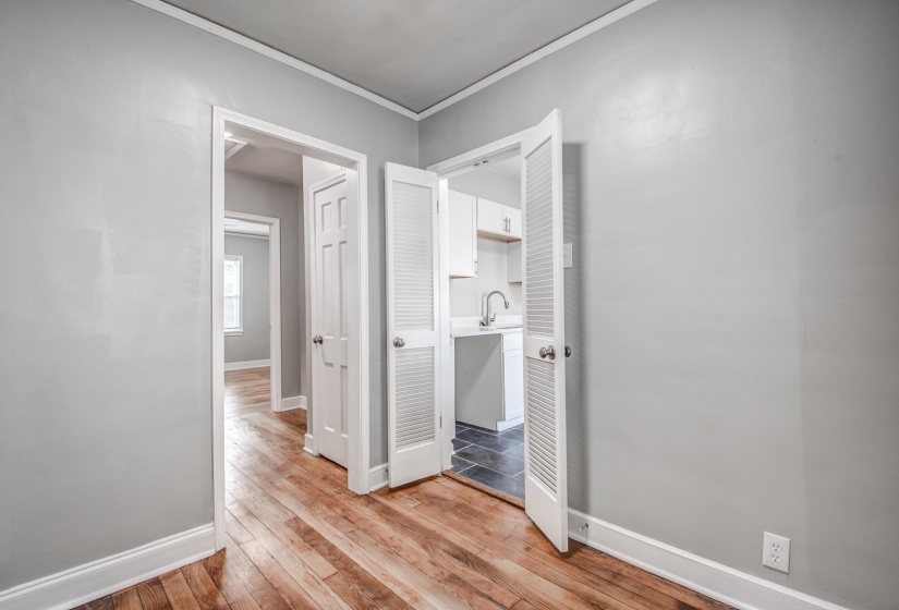 Hall featuring light wood-type flooring and ornamental molding