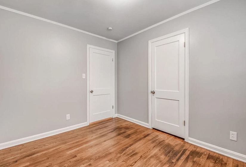 Spare room with ornamental molding and light wood-type flooring