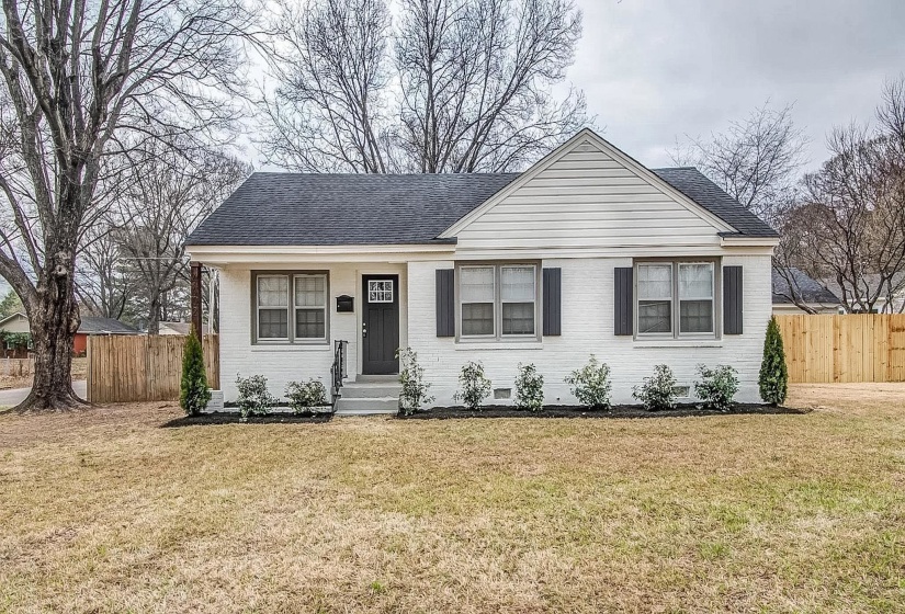 View of front facade with a shingled roof and brick siding