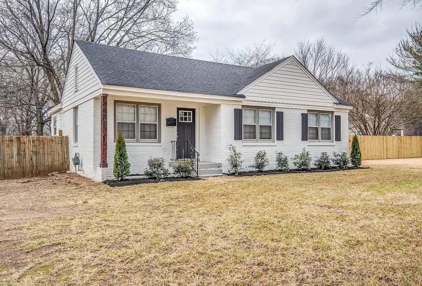 View of front facade featuring brick siding, roof with shingles, and a porch