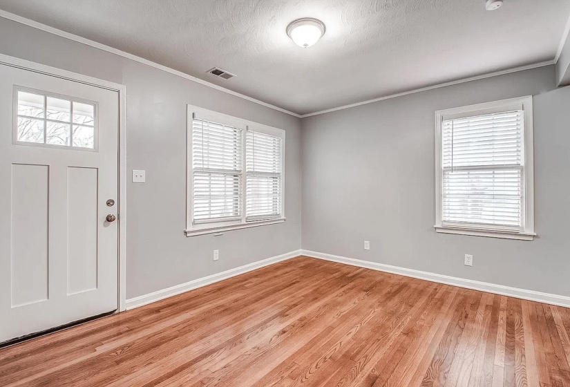 Entryway featuring light wood-style floors, ornamental molding, and a textured ceiling