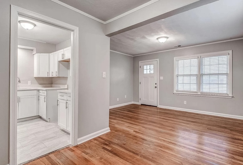 Foyer entrance featuring ornamental molding, light wood finished floors, and a textured ceiling