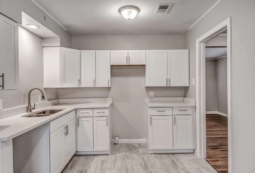 Kitchen featuring white cabinetry and light stone countertops