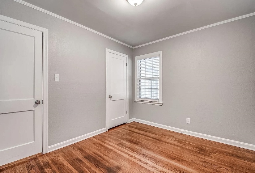Unfurnished bedroom with wood finished floors and crown molding