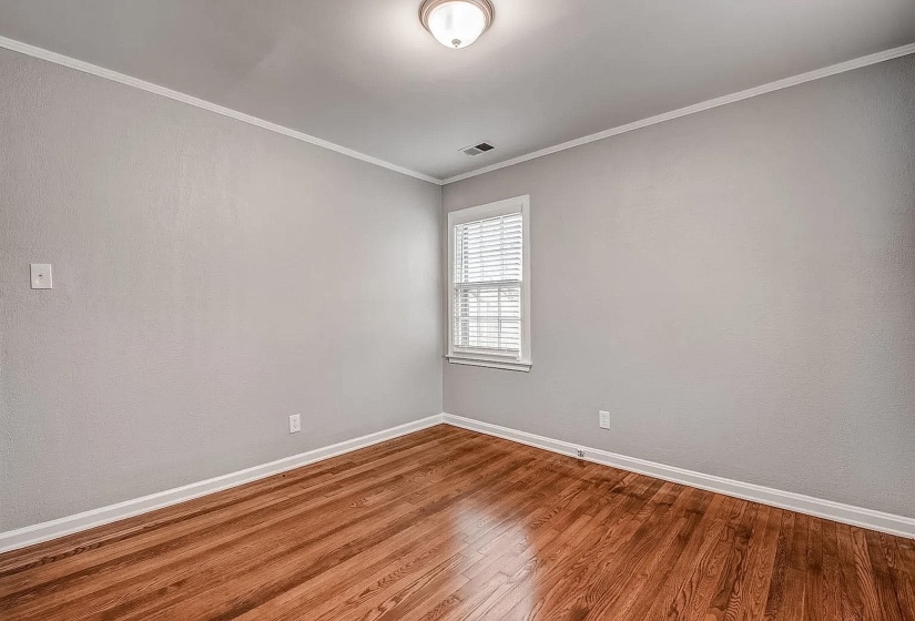 Unfurnished room featuring wood-type flooring and ornamental molding