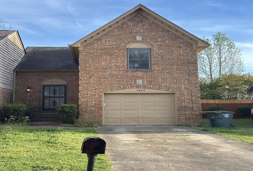 View of front of property with brick siding, driveway, entry steps, and a garage