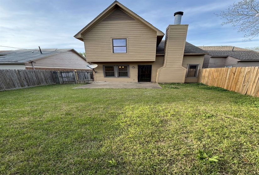 Back of house featuring a patio area, a chimney, and a fenced backyard