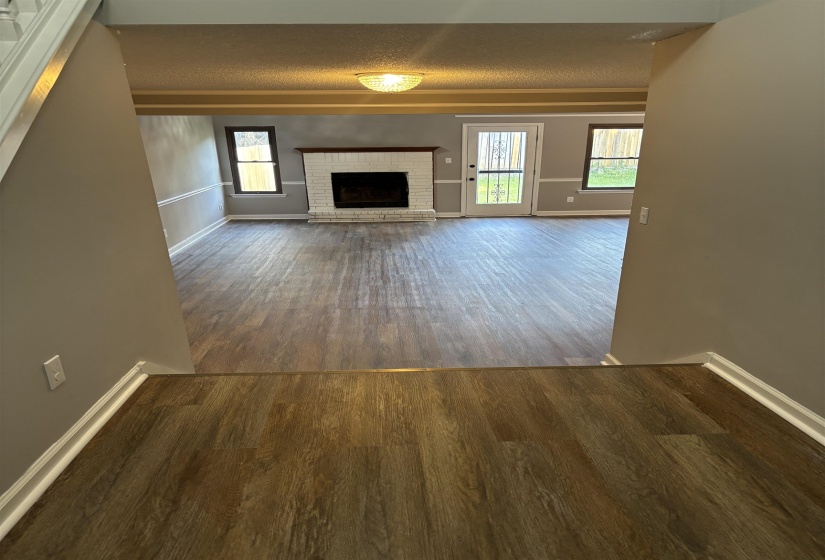 Unfurnished living room with dark wood-style floors and a fireplace