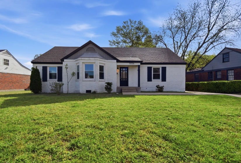 View of front of house with brick siding, a front lawn, and roof with shingles
